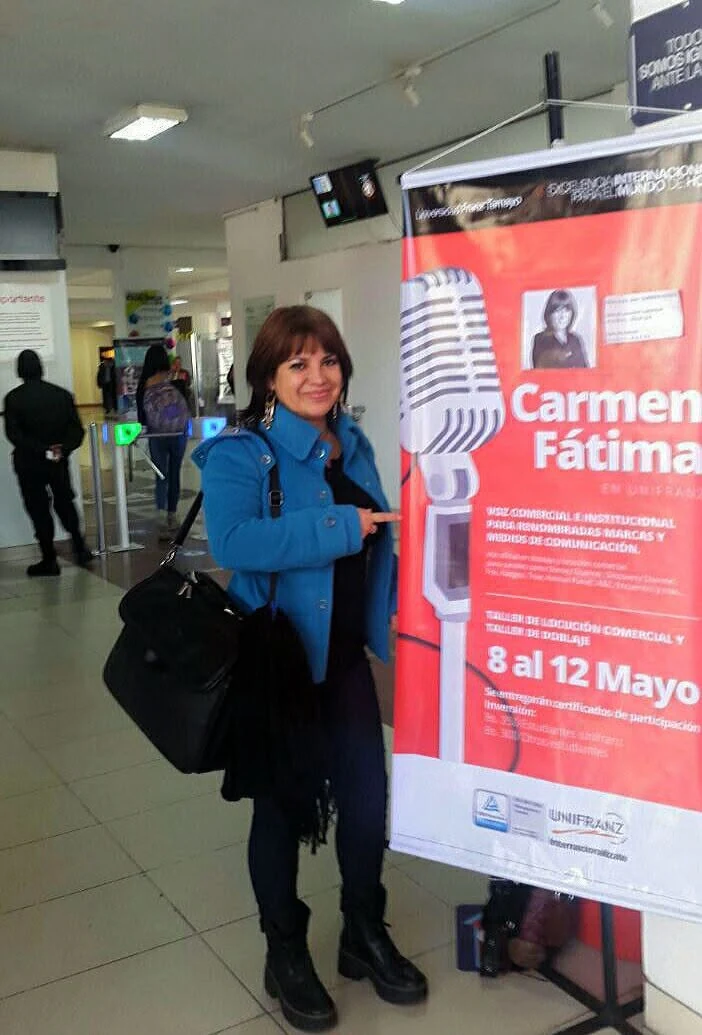 Carmen Fátima Saavedra junto al afiche de su Taller de Doblaje en UNIFRANZ, La Paz